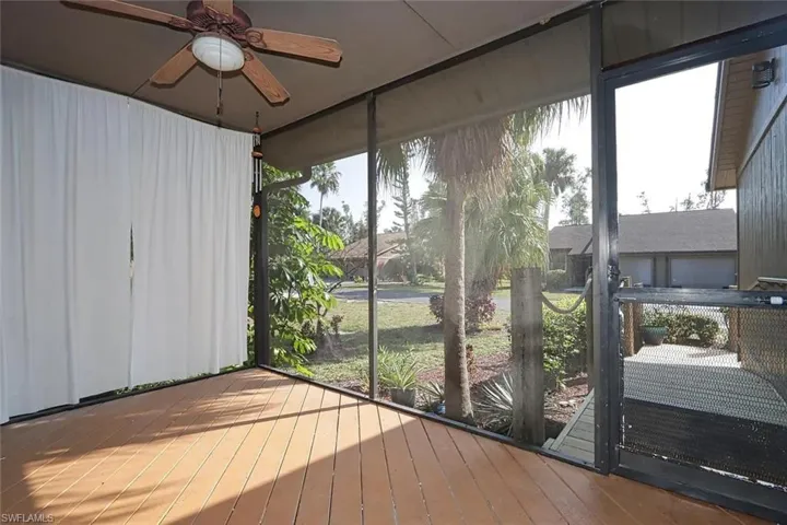 Unfurnished sunroom with a ceiling fan and a wooden deck