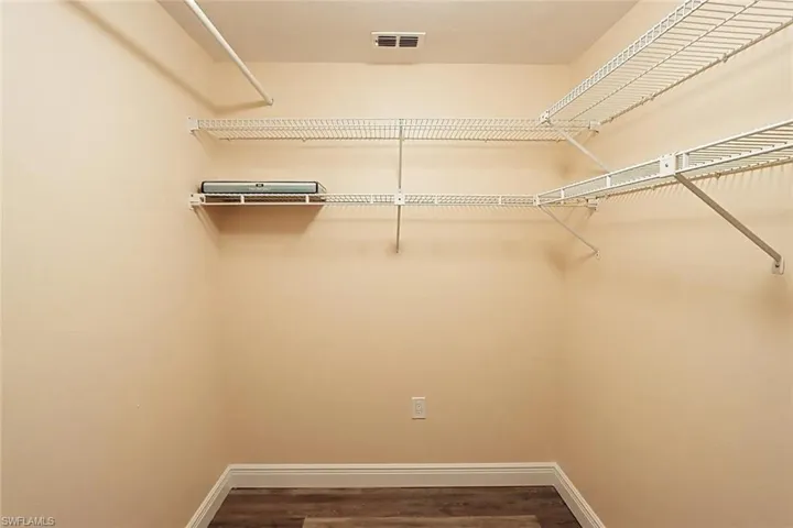 Walk in closet featuring dark wood-type flooring