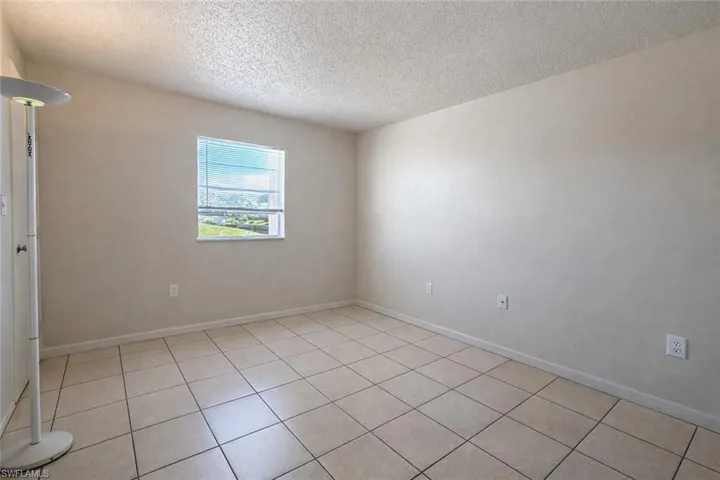 Spare room with a textured ceiling and light tile patterned flooring