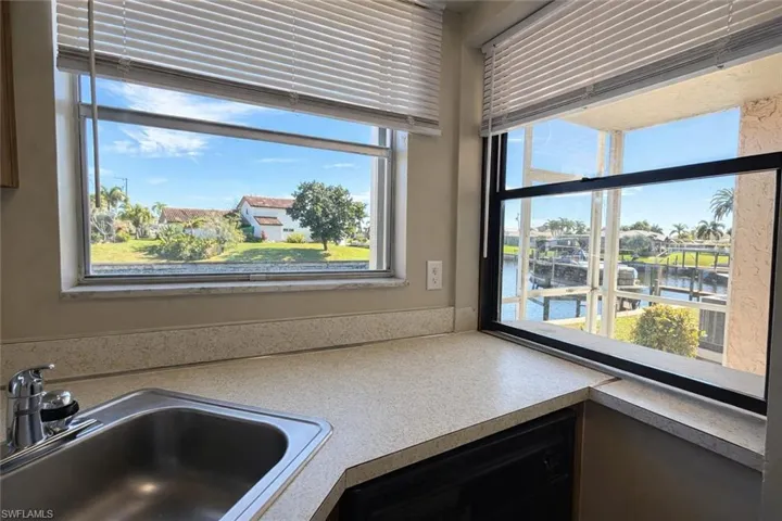 Kitchen view of nearby water, black dishwasher, and light countertops