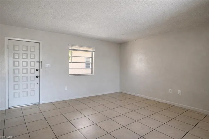 Empty room featuring a textured ceiling and baseboards