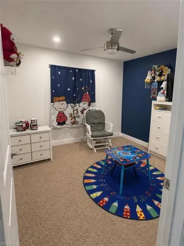 Carpeted room featuring a ceiling fan with integrated lighting, recessed lighting, and a painted accent wall