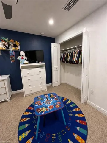 Light-colored carpeting provides a neutral base for this room featuring a prominent dark blue accent wall