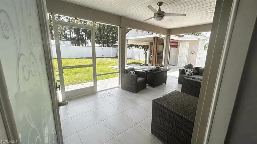 Screened patio with white tile flooring and a ceiling fan