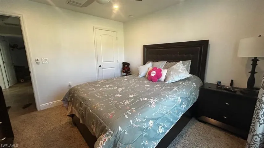 Carpeted room featuring a white interior door, a ceiling fan with integrated lighting, and recessed ceiling lights