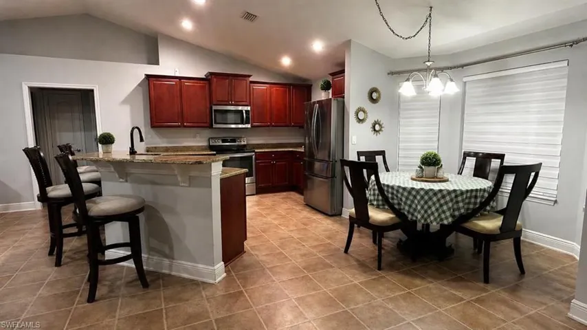 Kitchen with wood cabinetry, stainless steel appliances, and granite countertops