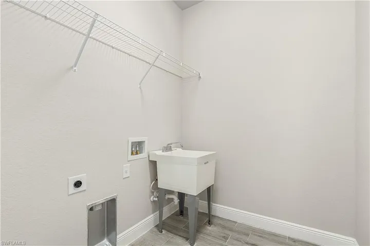Clothes washing area with hookup for an electric dryer, hookup for a washing machine, and wood-type flooring