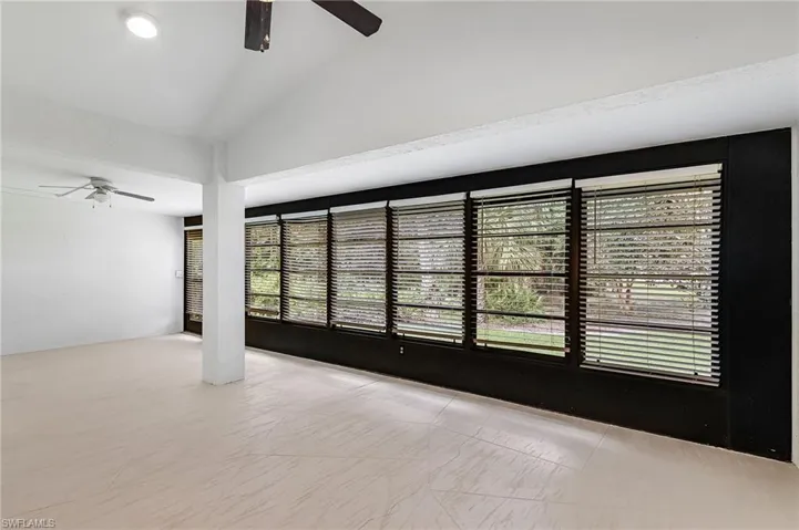 Empty room with lofted ceiling and ceiling fan