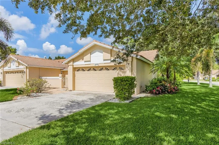 Ranch-style house with a tiled roof, stucco siding, a front lawn, and concrete driveway
