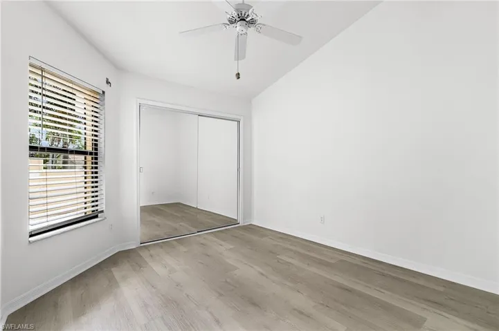 Unfurnished bedroom with light wood-style flooring, a closet, ceiling fan, and vaulted ceiling