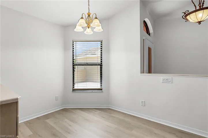 Unfurnished dining area featuring a chandelier and light wood-style floors