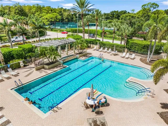 Community pool featuring a pergola, a patio area, and view of scattered trees