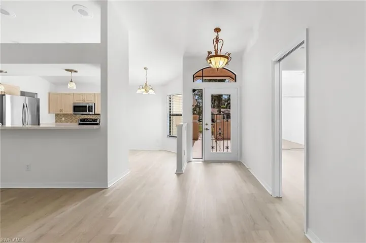 Entrance foyer with light wood-style floors and a chandelier