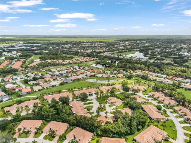 Aerial view of property and surrounding area featuring nearby suburban area and a nearby body of water