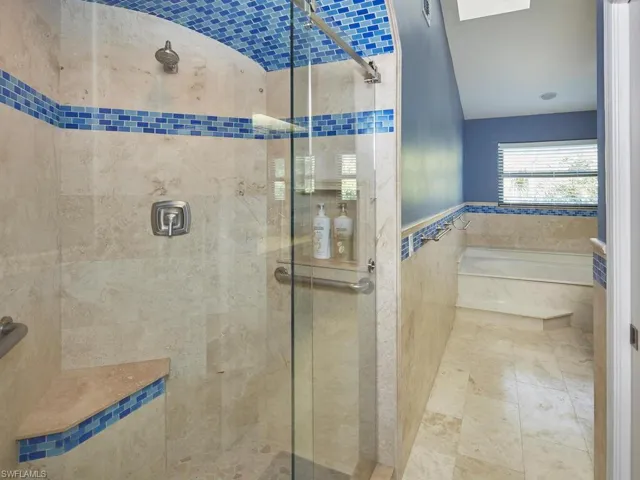 Walk in shower, with decorative tile.
