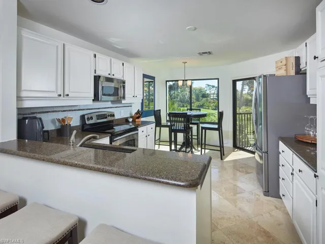 White cabinetry, stainless appliances, plenty of counter space AND a breakfast bar!