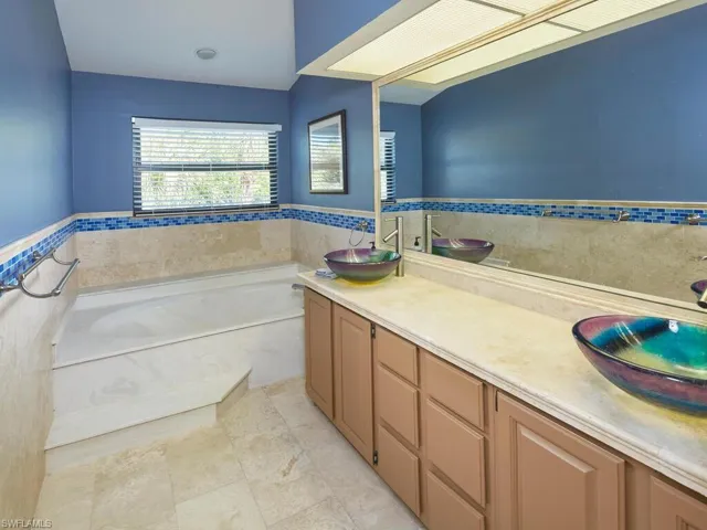 Spacious primary bathroom with a soaking tub and dual sinks.