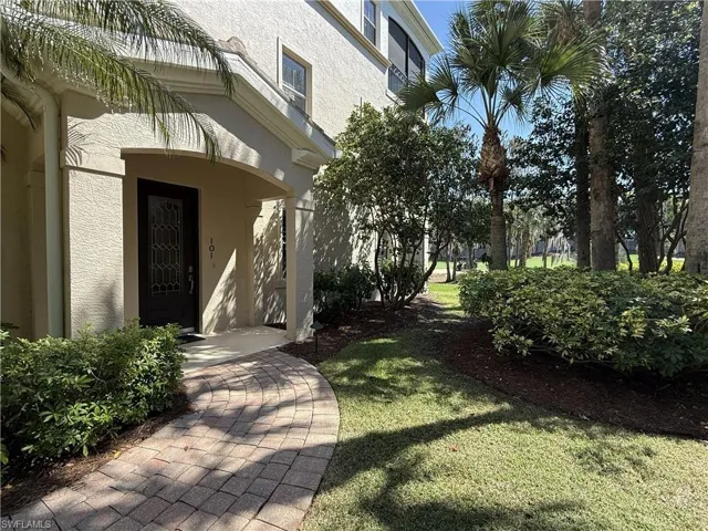 Entrance to property featuring a side yard and view of golf course