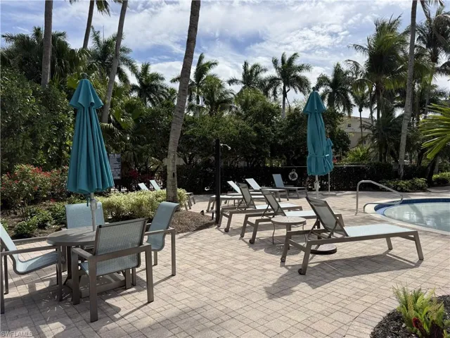Pool patio with plenty of chairs and umbrellas