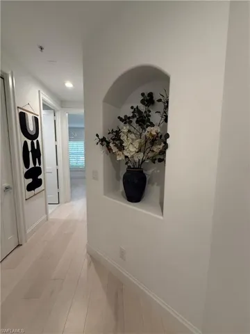 Corridor featuring light wood-type flooring and recessed lighting