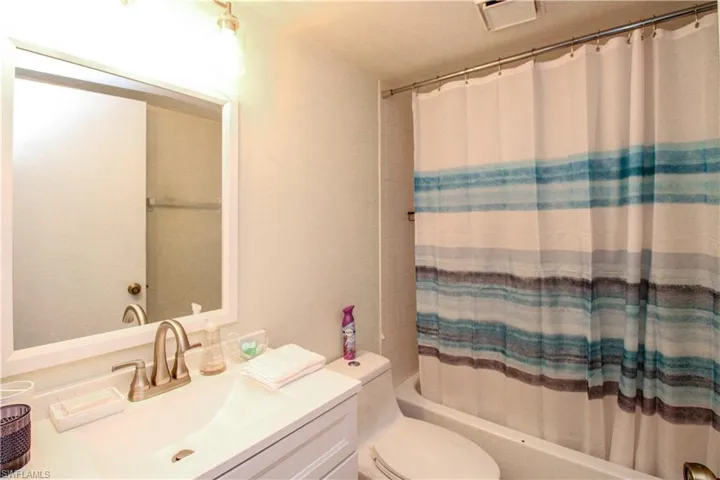 Full bathroom with vanity, shower / tub combo, and toilet