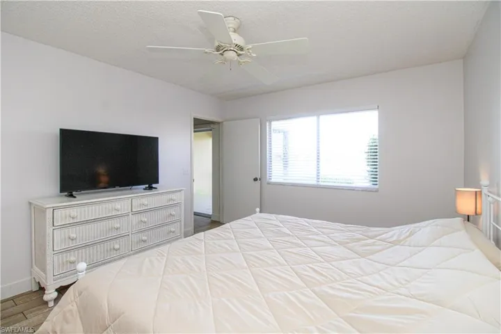 Bedroom featuring a textured ceiling, ceiling fan, and hardwood / wood-style flooring