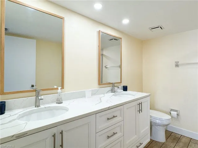 Bathroom with hardwood / wood-style floors, vanity, and toilet
