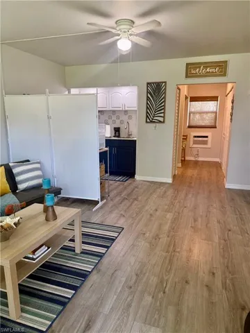 Living area with ceiling fan and light wood finished floors