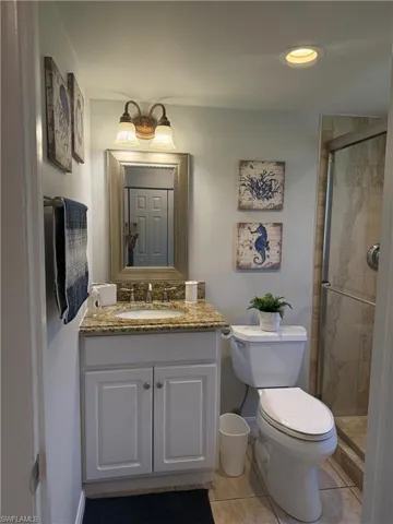 Bathroom featuring vanity, a shower stall, and tile patterned flooring