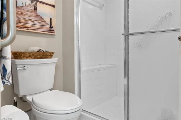 Full bathroom with toilet and a shower stall