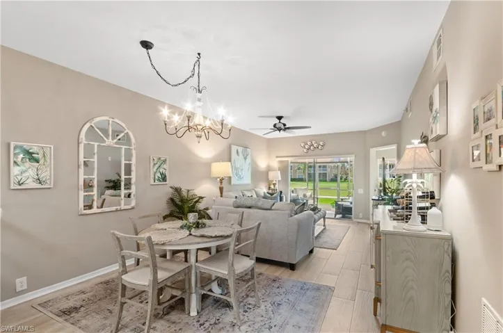 Dining area with light wood-type flooring, baseboards and chandelier