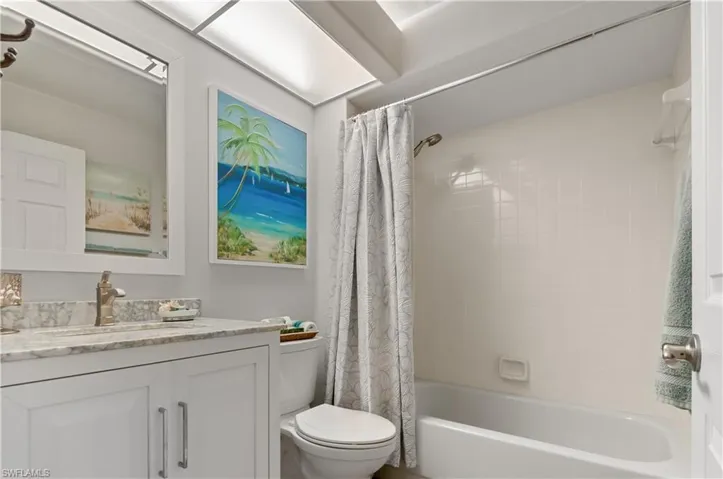 Full bathroom featuring vanity, shower / bath combo with shower curtain, and toilet