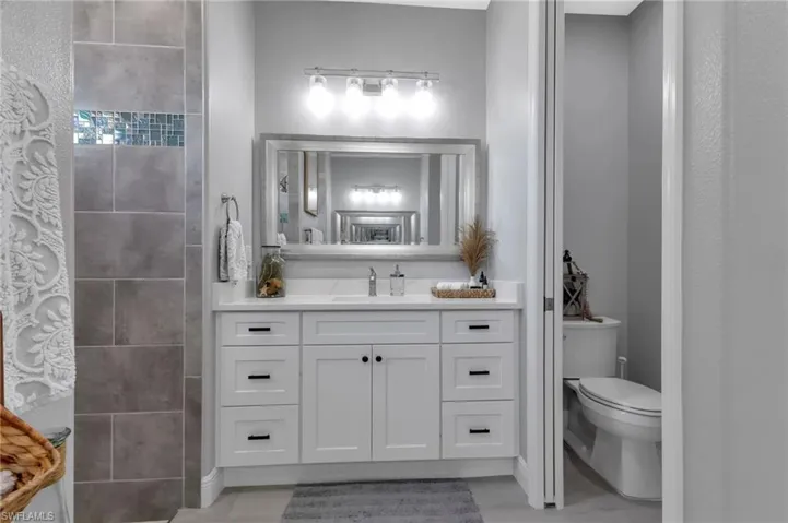 Bathroom featuring vanity, tile patterned floors, and toilet
