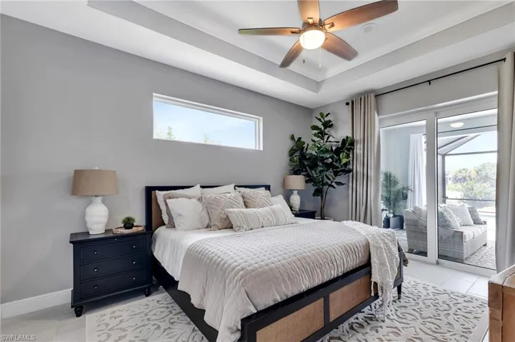Bedroom with access to outside, ornamental molding, a raised ceiling, and ceiling fan