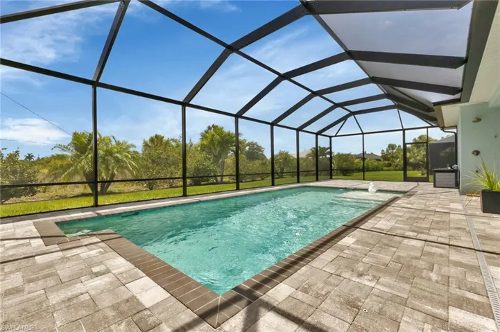 View of swimming pool featuring a patio area and glass enclosure
