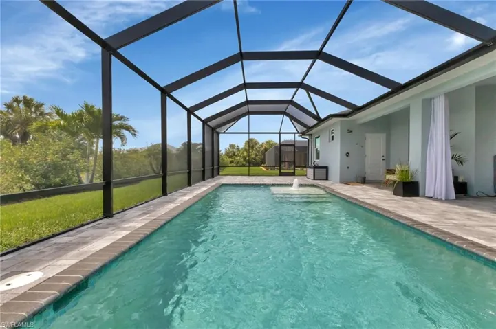 View of pool with a patio, a lanai, and a shed