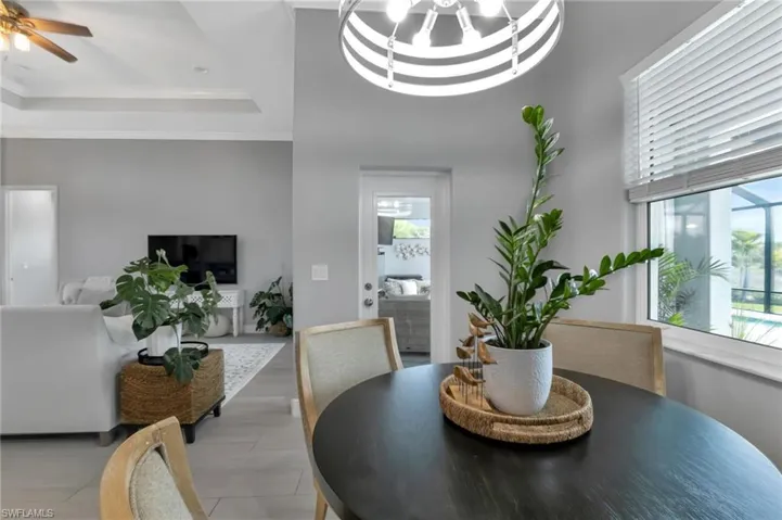 Dining room featuring ceiling fan, ornamental molding, and a tray ceiling
