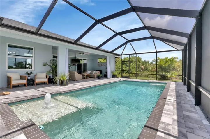 View of swimming pool featuring a lanai, an outdoor hangout area, ceiling fan, and a patio area