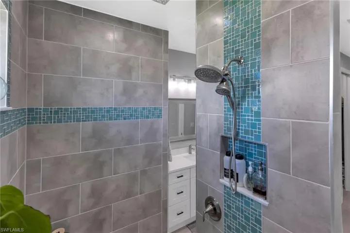 Bathroom featuring vanity and a tile shower