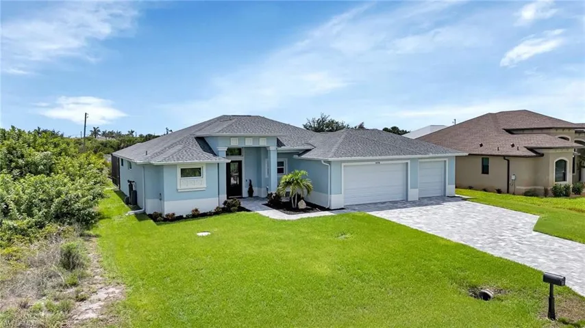 View of front of house with a garage and a front lawn