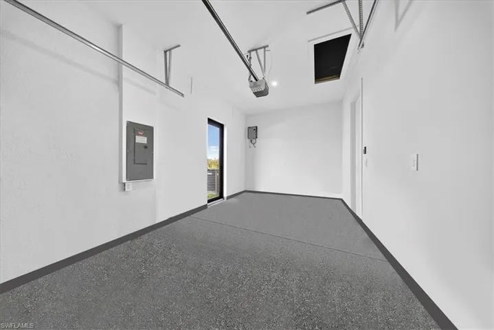 Garage with electric panel and baseboards