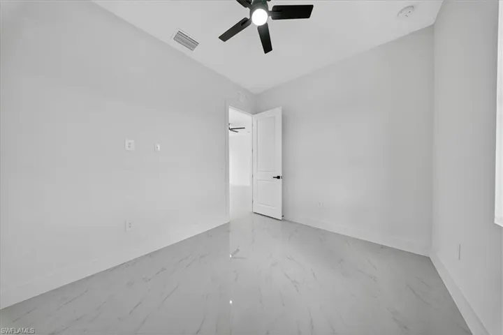 Empty room featuring baseboards and a ceiling fan