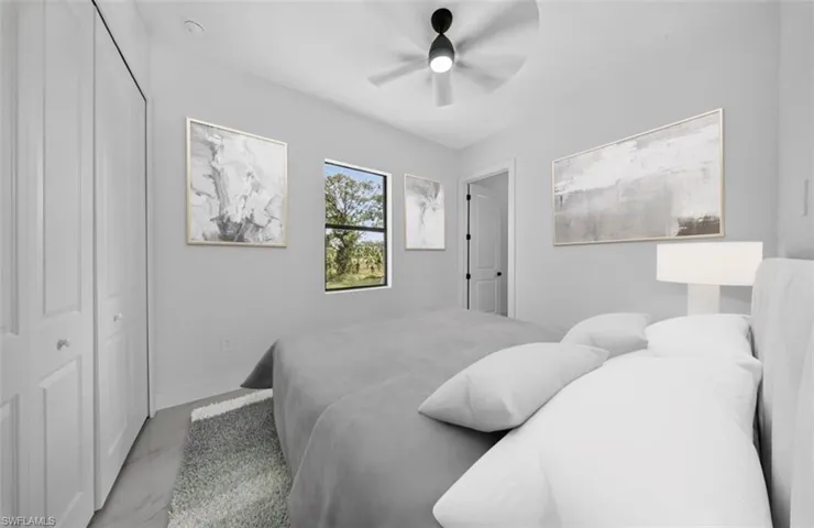 Bedroom featuring a closet, ceiling fan, and marble look tile flooring