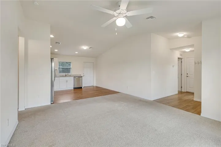 Living room with light colored carpet, and recessed lighting
