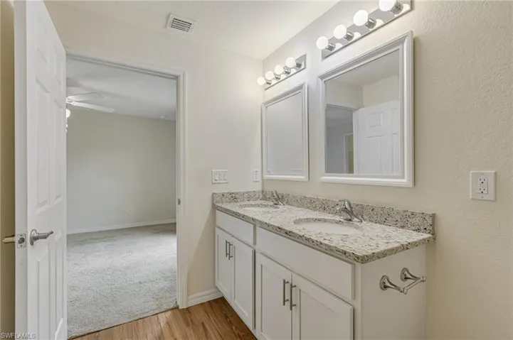 Bathroom with laminate floors, double vanities