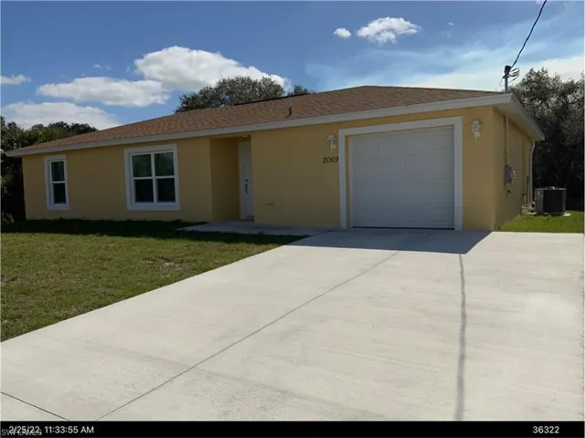 a front lawn, an attached garage, and concrete driveway