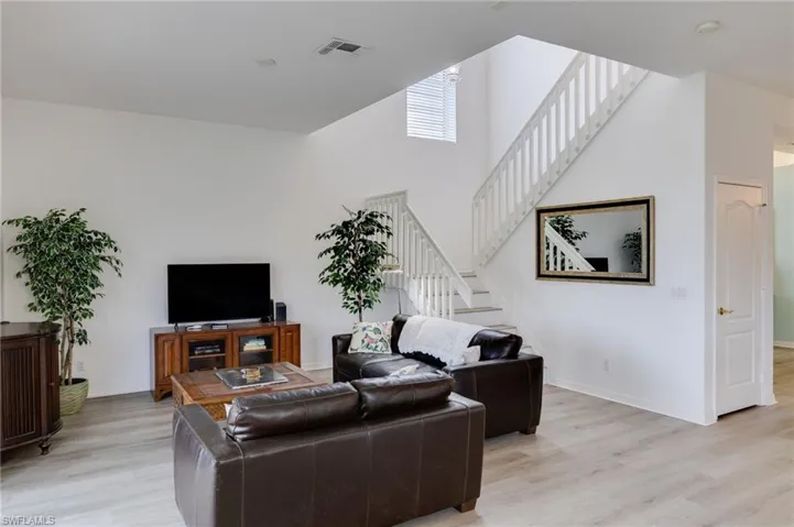 Living area featuring light vinyl flooring and a high ceiling