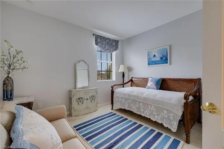 Bedroom with light colored carpet and baseboards