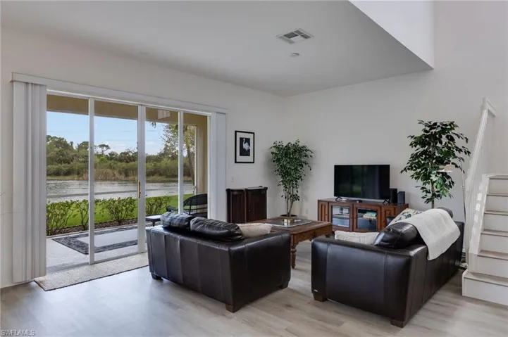 Living room featuring light vinyl flooring and stairs