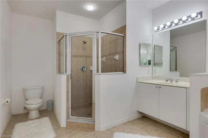 Bathroom featuring vanity, a stall shower, and light tile patterned floors